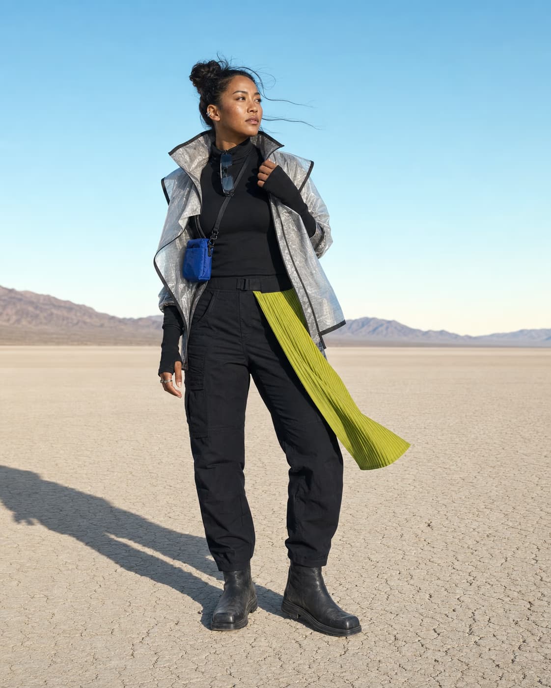 Full-length portrait in practical black layers, a silver shell, and a citron textile accent